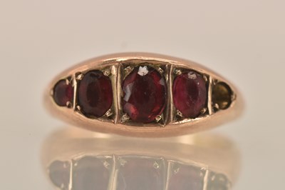 Lot 1346 - A 9ct yellow gold garnet set five stone ring...
