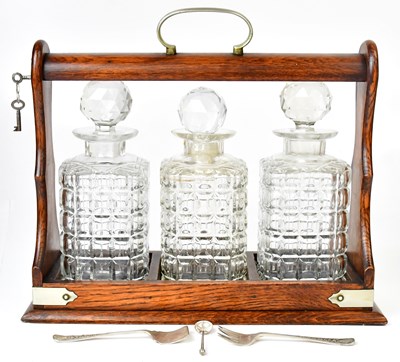 Lot 237 - A lockable wooden tantalus with three cut...