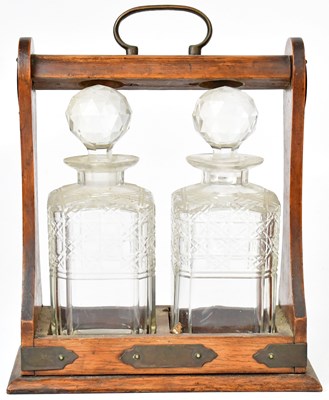 Lot 359 - A wooden tantalus, with two cut glass...