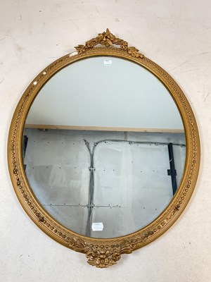 Lot 794 - An oval gilt mirror with decorative finials to...