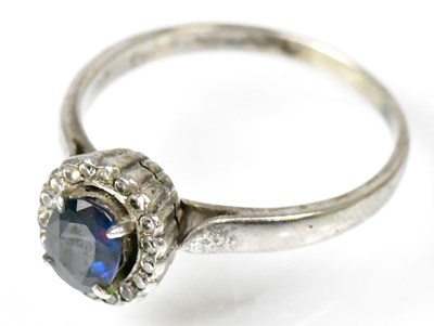 Lot 762 - A white metal ring set with central sapphire...