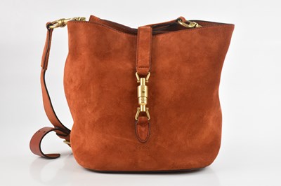 Lot 1402 - GUCCI; a burnt orange suede bucket bag, with...