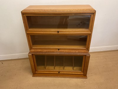 Lot 672 - An oak veneered three tiered glass fronted...