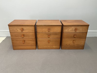 Lot 1013 - Three mid century teak bedside chests, each...
