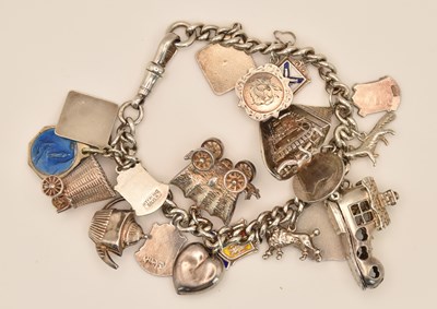 Lot 1554 - A silver charm bracelet with eighteen charms...