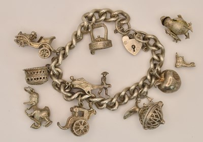 Lot 1555 - A silver charm bracelet with ten charms (three...