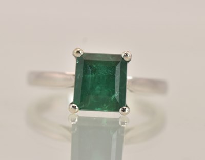 Lot 1321 - An 18K white gold emerald set dress ring, the...