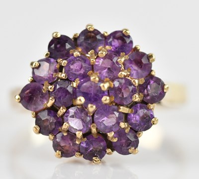 Lot 697 - A 9ct yellow gold cluster ring set with purple...