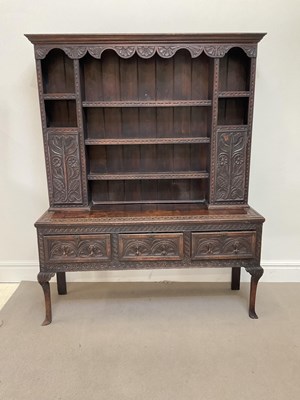 Lot 1037 - An early 20th century carved oak dresser, the...