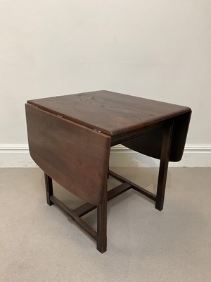 Lot 1018 - ERCOL; a stained oak drop-leaf dining table on...