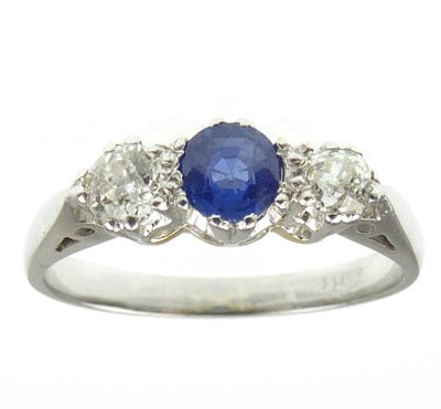 Lot 943 - An 18ct white gold diamond and sapphire ring,...