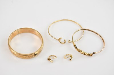 Lot 85 - A 9ct yellow gold hinged snap bangle, two...