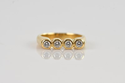 Lot 511 - A yellow metal diamond set four stone ring,...