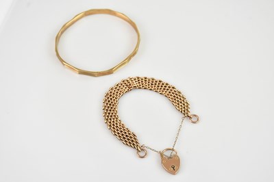 Lot 78 - A 9ct yellow gold engine turned bangle,...