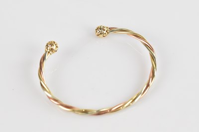 Lot 117 - A trimetal twisted bangle, tests as 9.23kt...