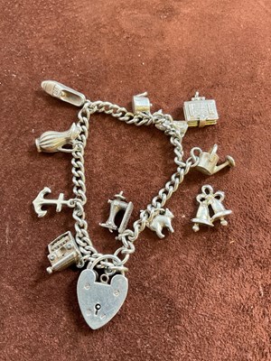 Lot 603 - A silver charm bracelet set with several...