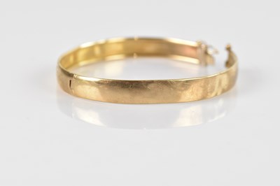Lot 140 - A yellow metal hinged snap bangle with...