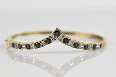 Lot 99 - A 9ct yellow gold hinged snap bangle, set with...