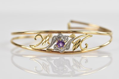 Lot 118 - A yellow metal bangle set with a round...