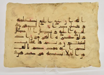 Lot 1023 - An ink on vellum Kufic Quran page, 27 x 19.5cm.