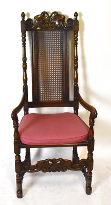 Lot 1610 - A large early 20th century oak open arm elbow chair with caned back and solid seat