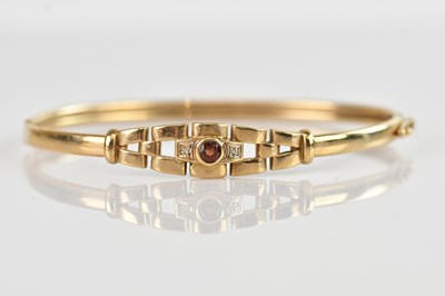 Lot 107 - A yellow metal hinged snap bangle, set with a...
