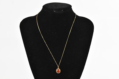 Lot 437 - A 9ct yellow gold pendant set with an orange...