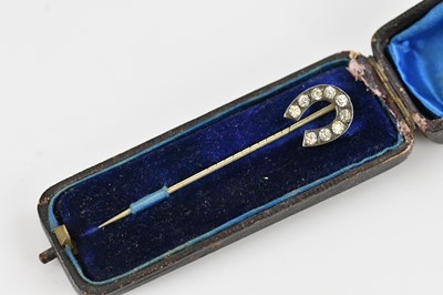 Lot 213 - A white metal stick pin with horseshoe...