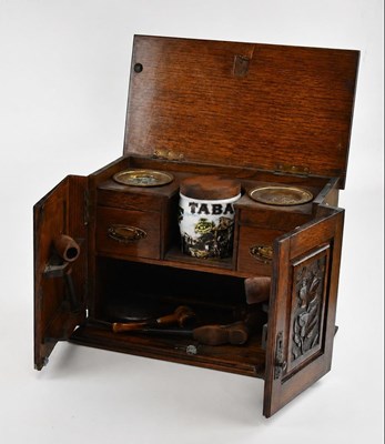 Lot 2195 - A 1920s carved oak smoker's cabinet, with...
