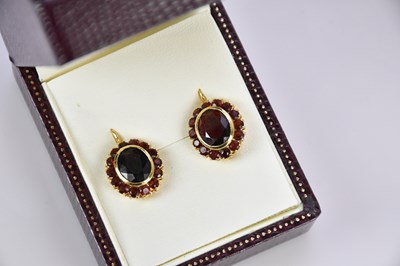 Lot 482 - A pair of yellow metal garnet set oval clip...