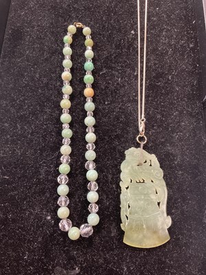 Lot 261 - A Chinese green carved hardstone pendant,...