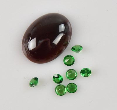 Lot 210 - LOOSE GEMSTONES; an oval cut garnet cabochon...
