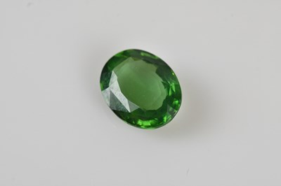 Lot 56 - An oval cut loose gemstone, pale green,...