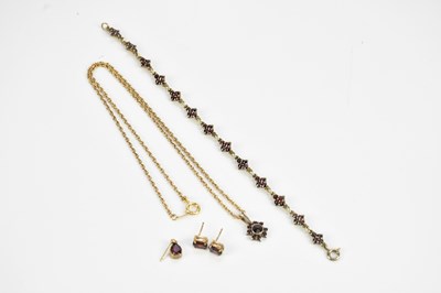Lot 382 - A white metal garnet set pendant, suspended on...