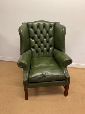 Lot 669 - A green leather button and wing back chair...