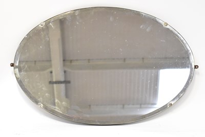 Lot 69 - A 1940s oval wall mirror with bevelled plate,...
