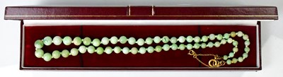 Lot 825 - A jade necklace with graduated beads, and...