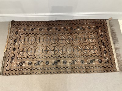 Lot 1403 - An Eastern brown ground rug with elephant foot...