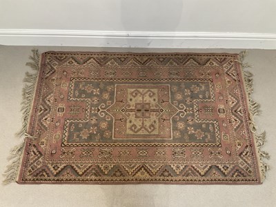 Lot 1397 - An Eastern rug with stylised detail on a pink...