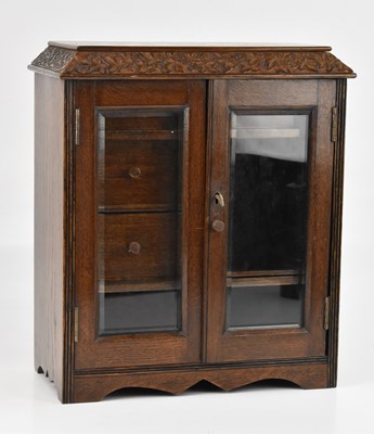 Lot 516 - A 1920s oak smoker's cabinet, with two glazed...
