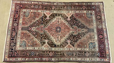 Lot 805 - A hand woven Persian rug with crimson coloured...