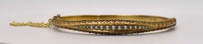 Lot 569 - A 15ct gold Edwardian seed pearl bangle, in a...