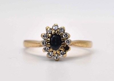 Lot 604 - A 9ct gold sapphire and diamond cluster ring,...