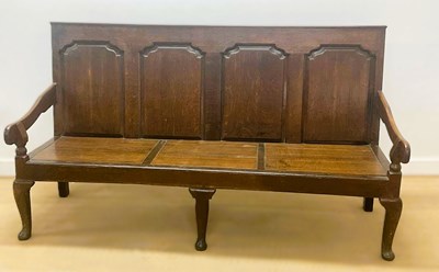 Lot 700 - A George III oak settle with four back panels...
