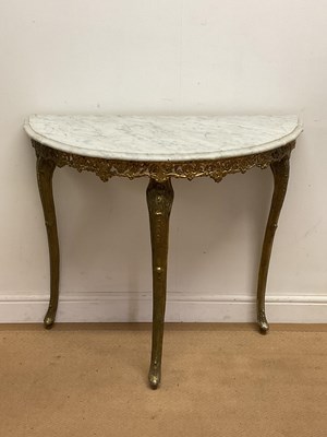 Lot 703 - A demi-lune console table with a gilded brass...