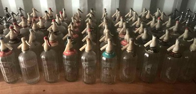 Lot 81 - Sixty glass soda syphons with plastic tops,...