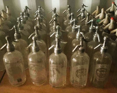 Lot 82 - Thirty glass soda syphons with metal or chrome...