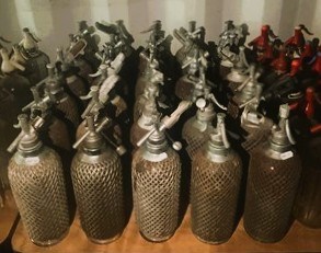 Lot 84 - Thirty glass and mesh soda syphons with metal...