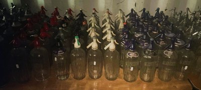 Lot 85 - Sixty glass soda syphons with plastic tops,...
