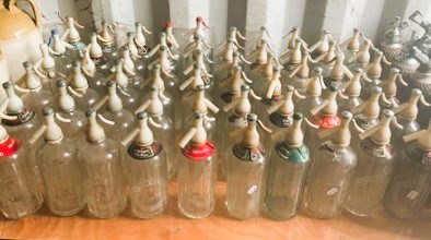 Lot 95 - Sixty glass soda syphons with plastic tops,...